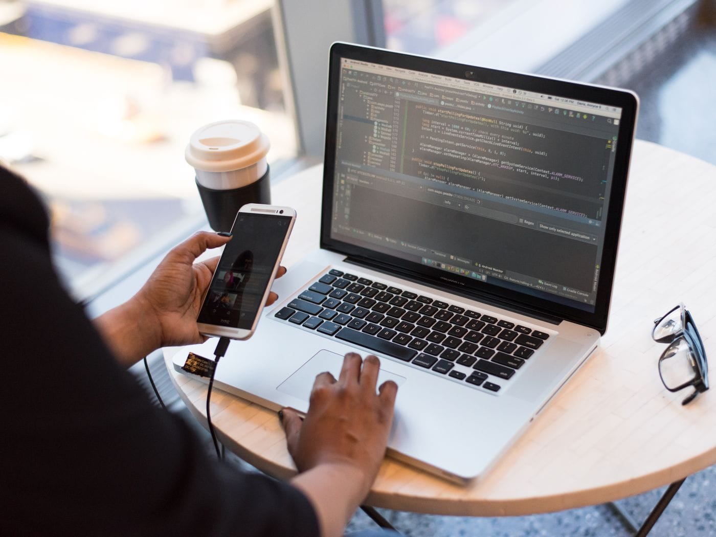 Mobile app developer testing React Native application interface across iOS and Android test devices